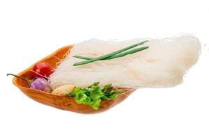 Raw rice noodles in a bowl on white background photo