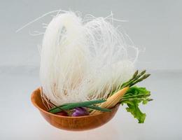 Raw rice noodles in a bowl on white background photo