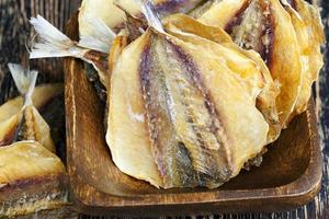 dried and butchered small fish on a wooden table photo