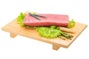 Tuna raw steak on wooden plate and white background photo