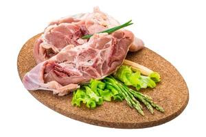 Raw lamb on wooden plate and white background photo