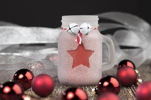 christmas candle in a glass jar and other decorations photo