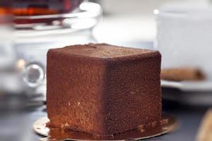 delicious chocolate cake with a cube shape on the table photo
