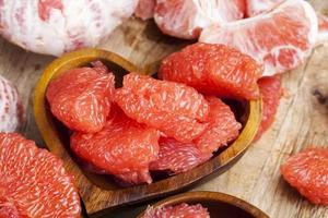 peeled red grapefruit divided into slices photo