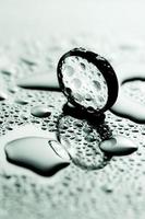 Cold monochrome minimal still life image of a round sphere on wet shiny surface. photo