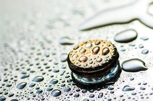 Abstract golden shiny object with droplets. Round wet object close up view. photo