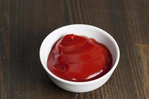 ketchup de tomate rojo vertido en un plato rojo foto