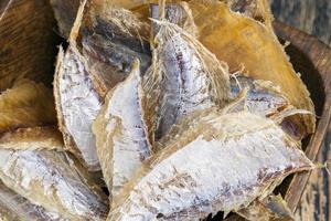 dried and butchered small fish on a wooden table photo