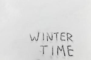 the words winter time drawn on the snow photo