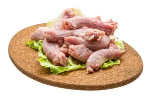 Raw chicken neck on wooden plate and white background photo