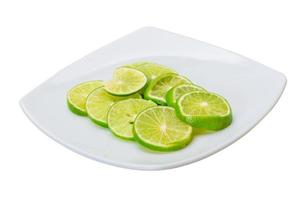 Sliced lime on the plate and white background photo