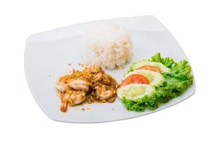 Shrimps with garlic and rice on the plate and white background photo