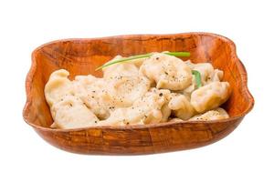 Vareniki - stuffed dumplings in a bowl on white background photo