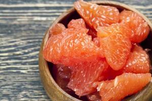 peeled red grapefruit divided into slices photo