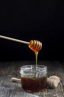 thick and sweet buckwheat honey of dark red color photo