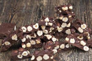 milk chocolate with whole and chunks of hazelnuts photo