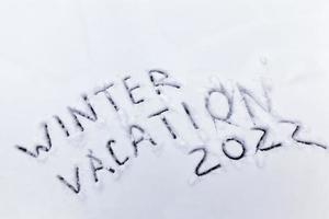 palabras vacaciones de invierno dibujadas en la nieve foto