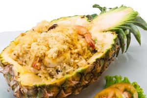 Pineapple salad with seafood on the plate and white background photo