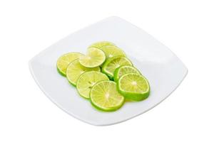 Sliced lime on the plate and white background photo