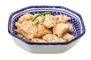 Vareniki - stuffed dumplings in a bowl on white background photo