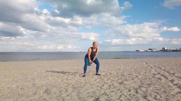 Young woman exercise on beach speeded up clip video