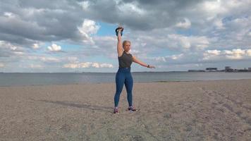 ung kvinna tränar på stranden i realtid 2 video
