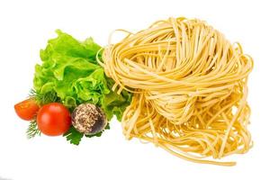 Raw egg noodles on white background photo