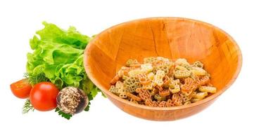 Raw pasta in a bowl on white background photo