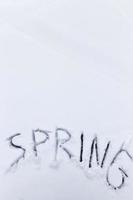 the words spring drawn on the snow photo