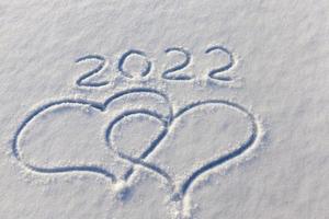 the inscription about the new year 2022 on the snow in winter photo
