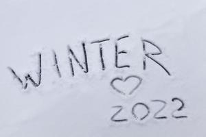 figures and the date of 2022 drawn on the snow photo