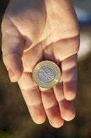 moneda en manos de un niño foto