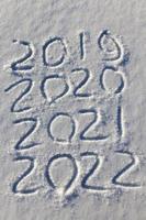 the inscription about the new year 2022 on the snow in winter photo