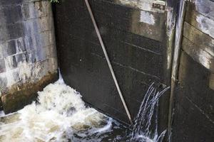 a leaking part of an old wooden dam photo