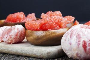 peeled red grapefruit divided into slices photo