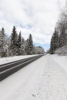 paved road covered with snow in winter photo