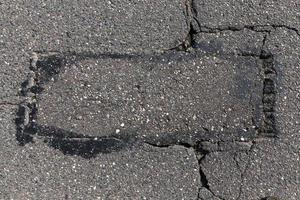 an asphalt road with a lot of holes and damage photo