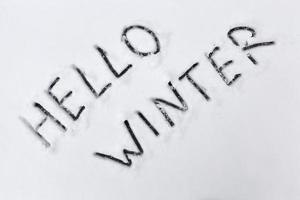 the words hello winter drawn on the snow photo