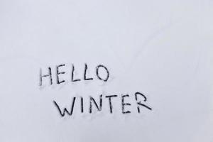 las palabras hola invierno dibujadas en la nieve foto