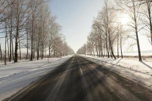 paved road covered with snow in winter photo