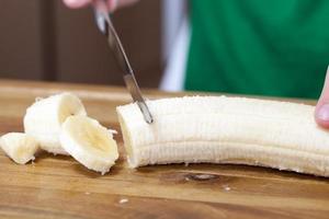 one banana is cut on a food slicing board photo