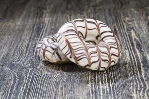 a fresh doughnut covered with white chocolate , closeup photo