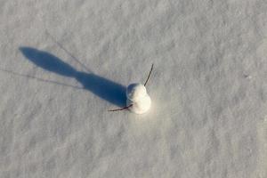 un pequeño muñeco de nieve en la temporada de invierno, de cerca foto