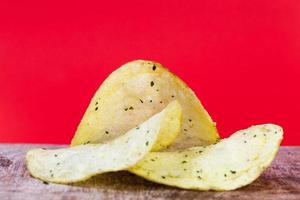 thin potato chips, crispy chips made from potatoes and deep fried photo