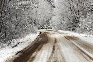 the road covered with snow to a winter season photo