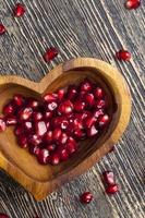 fresh pomegranate seeds in a heart shaped bowl photo