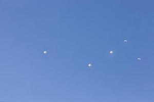 skydivers descending in the blue sky photo
