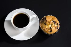 a delicious fresh bun and a cup of black aromatic coffee photo