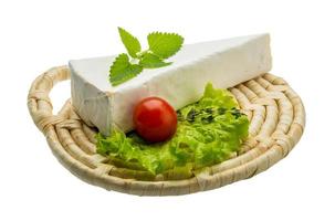 Brie cheese with thyme on wooden plate and white background photo