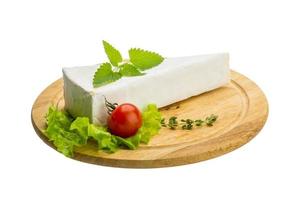 Brie cheese with thyme on wooden plate and white background photo